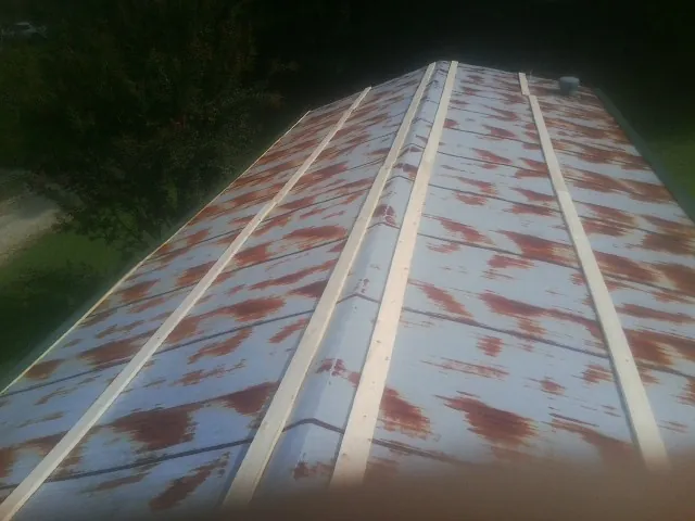 Rusted metal roof panels with new wood purlins before replacement — Storm Damage Roof Repair in Buchtel by Roofing Brothers